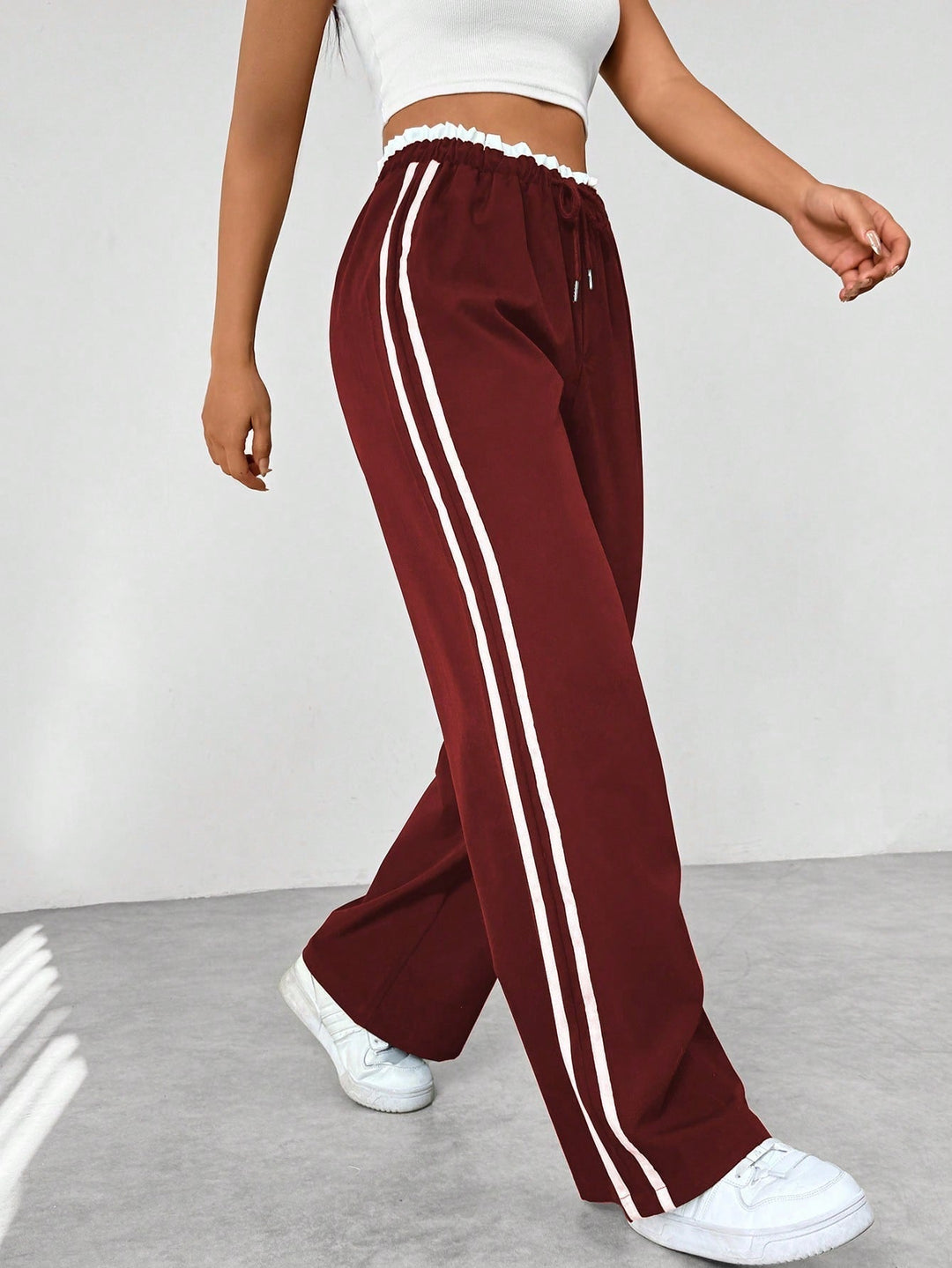 Women's wide leg trousers featuring an adjustable drawstring waist, sporty side stripes, and a lightweight design for a casual and comfortable look. 8