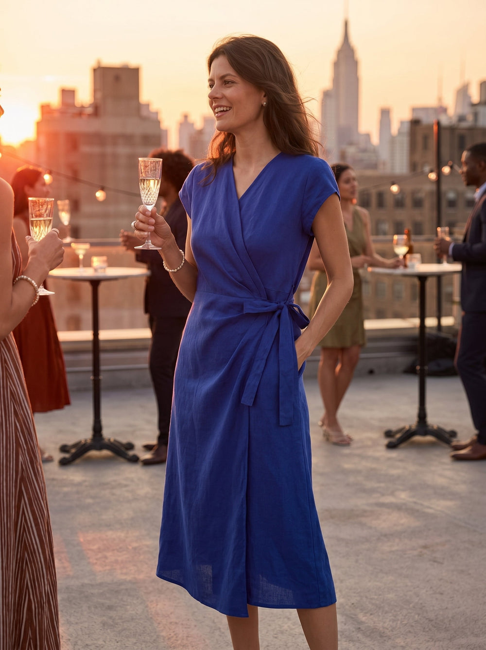 Womens linen midi wedding guest dress in cobalt blue featuring a wrap-tie waist and stylish cap sleeves. 1