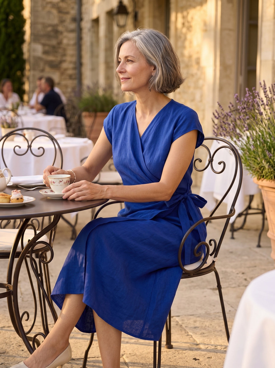 Womens linen midi wedding guest dress in cobalt blue featuring a wrap-tie waist and stylish cap sleeves. 2