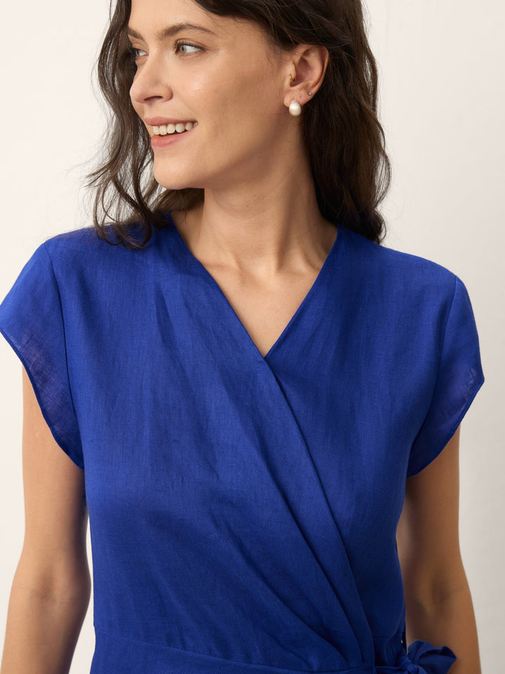 Womens linen midi wedding guest dress in cobalt blue featuring a wrap-tie waist and stylish cap sleeves. 5