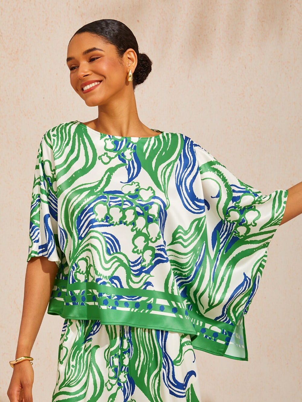 Womens top featuring an asymmetric hem and batwing sleeves in an abstract floral satin design, perfect for stylish and comfortable everyday wear. 1