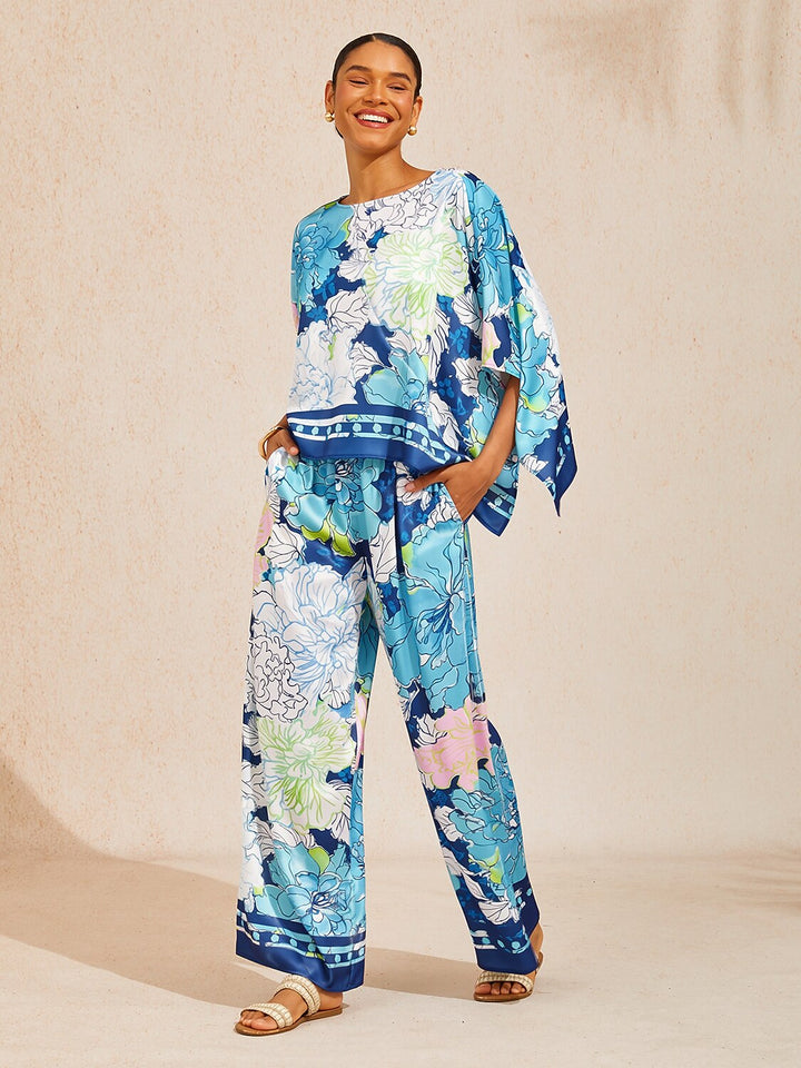 Womens top featuring an asymmetric hem and batwing sleeves in an abstract floral satin design, perfect for stylish and comfortable everyday wear. 15