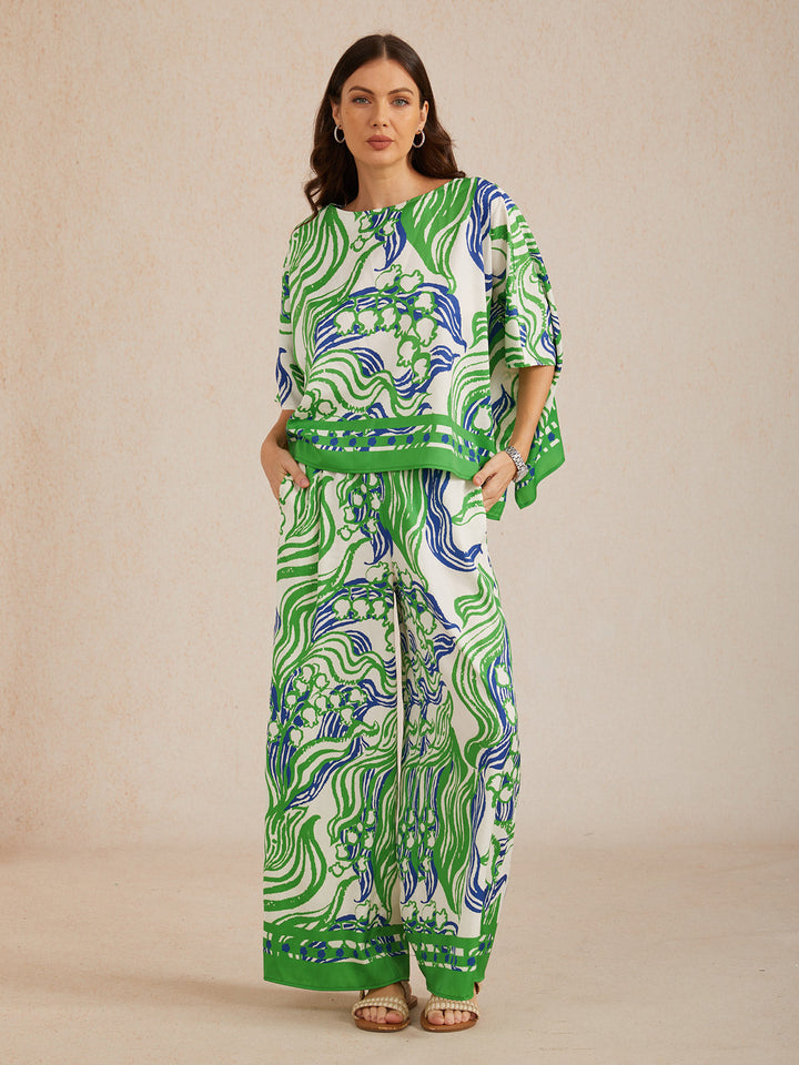 Womens top featuring an asymmetric hem and batwing sleeves in an abstract floral satin design, perfect for stylish and comfortable everyday wear. 4