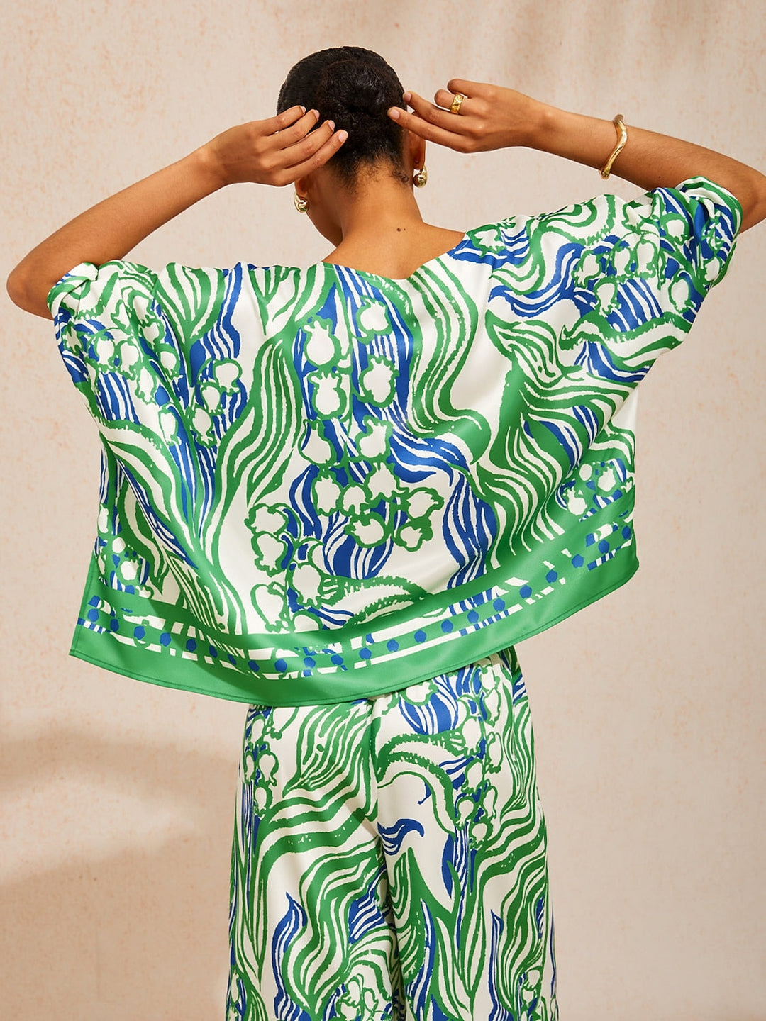 Womens top featuring an asymmetric hem and batwing sleeves in an abstract floral satin design, perfect for stylish and comfortable everyday wear. 6