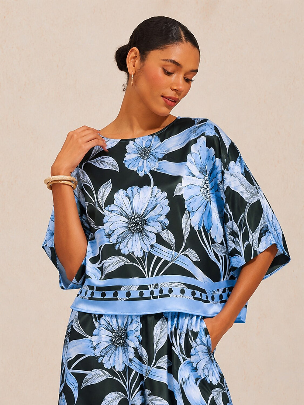Womens silky satin floral blouse in glacier blue featuring an asymmetrical hem and dolman sleeves, perfect for stylish casual wear. 1
