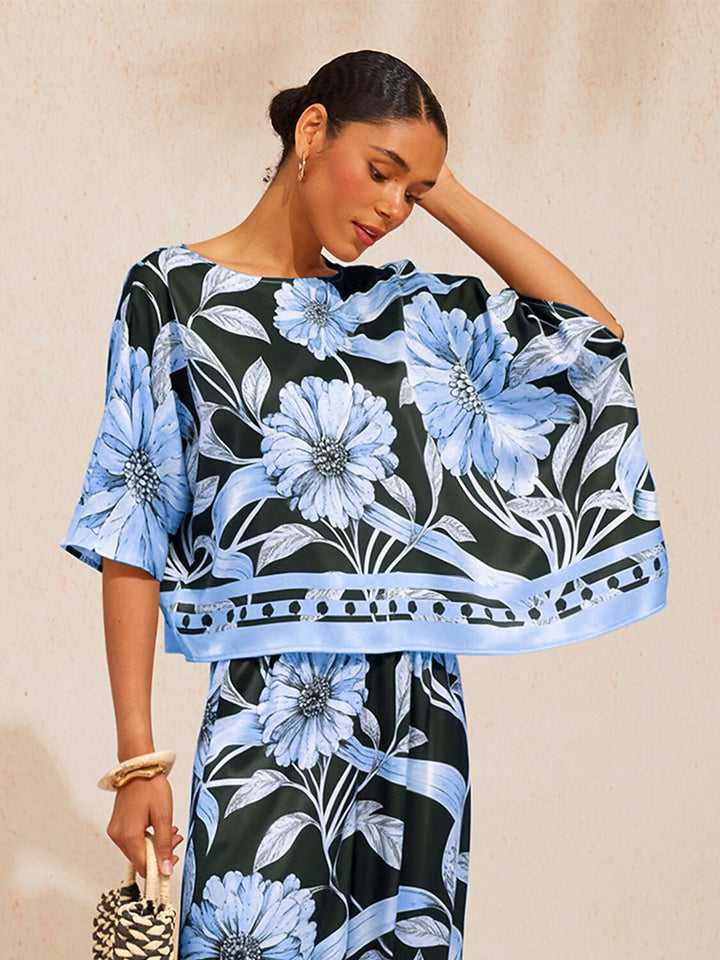 Womens silky satin floral blouse in glacier blue featuring an asymmetrical hem and dolman sleeves, perfect for stylish casual wear. 3