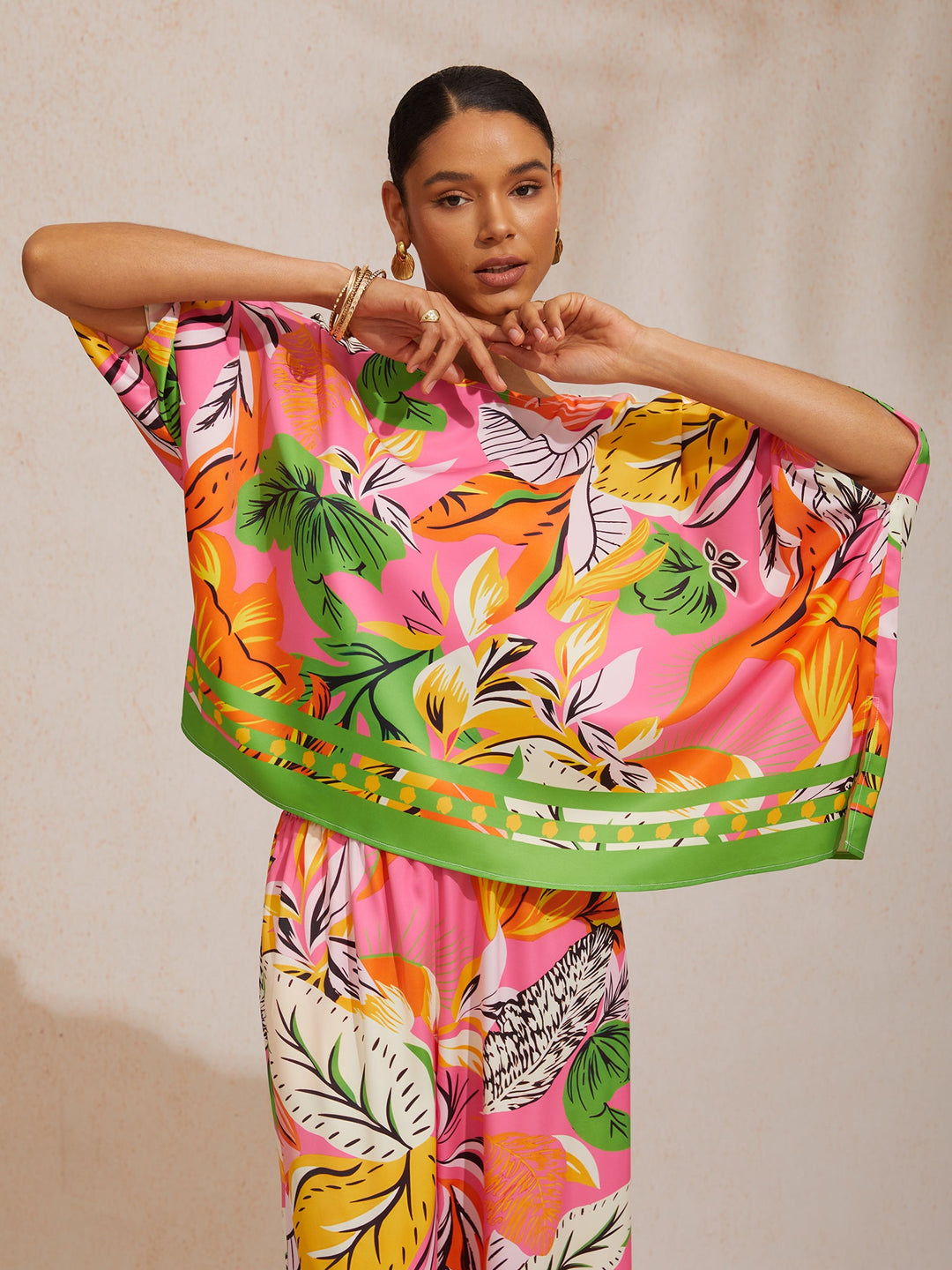 Womens top featuring an asymmetrical hem and kimono sleeves, made of silky satin with a vibrant tropical print, perfect for stylish summer outfits. 1
