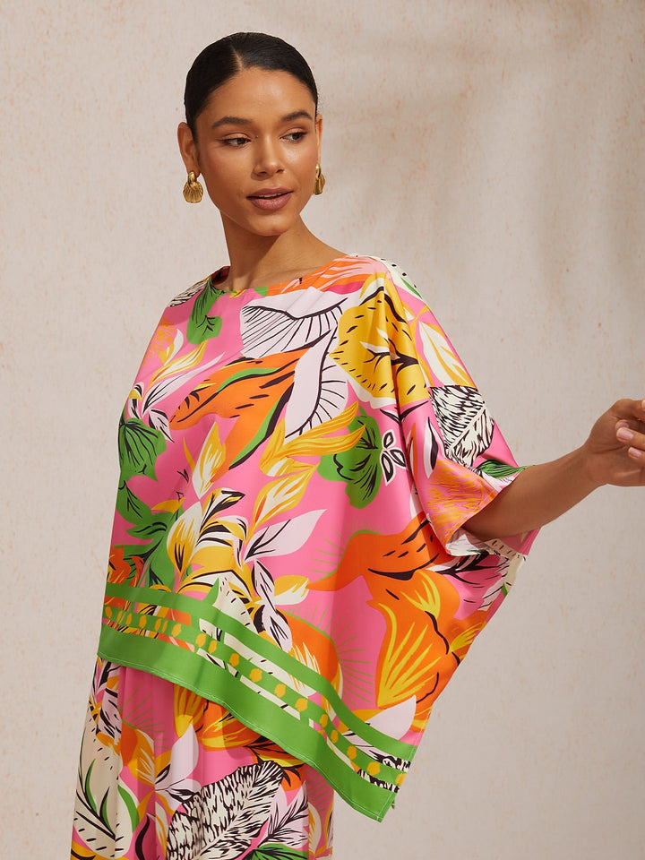 Womens top featuring an asymmetrical hem and kimono sleeves, made of silky satin with a vibrant tropical print, perfect for stylish summer outfits. 7